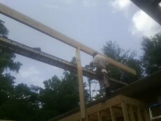 Carpenter setting a ridge beam over a new addition frame — Ice Dam Removal by Roofing Brothers in Jackson